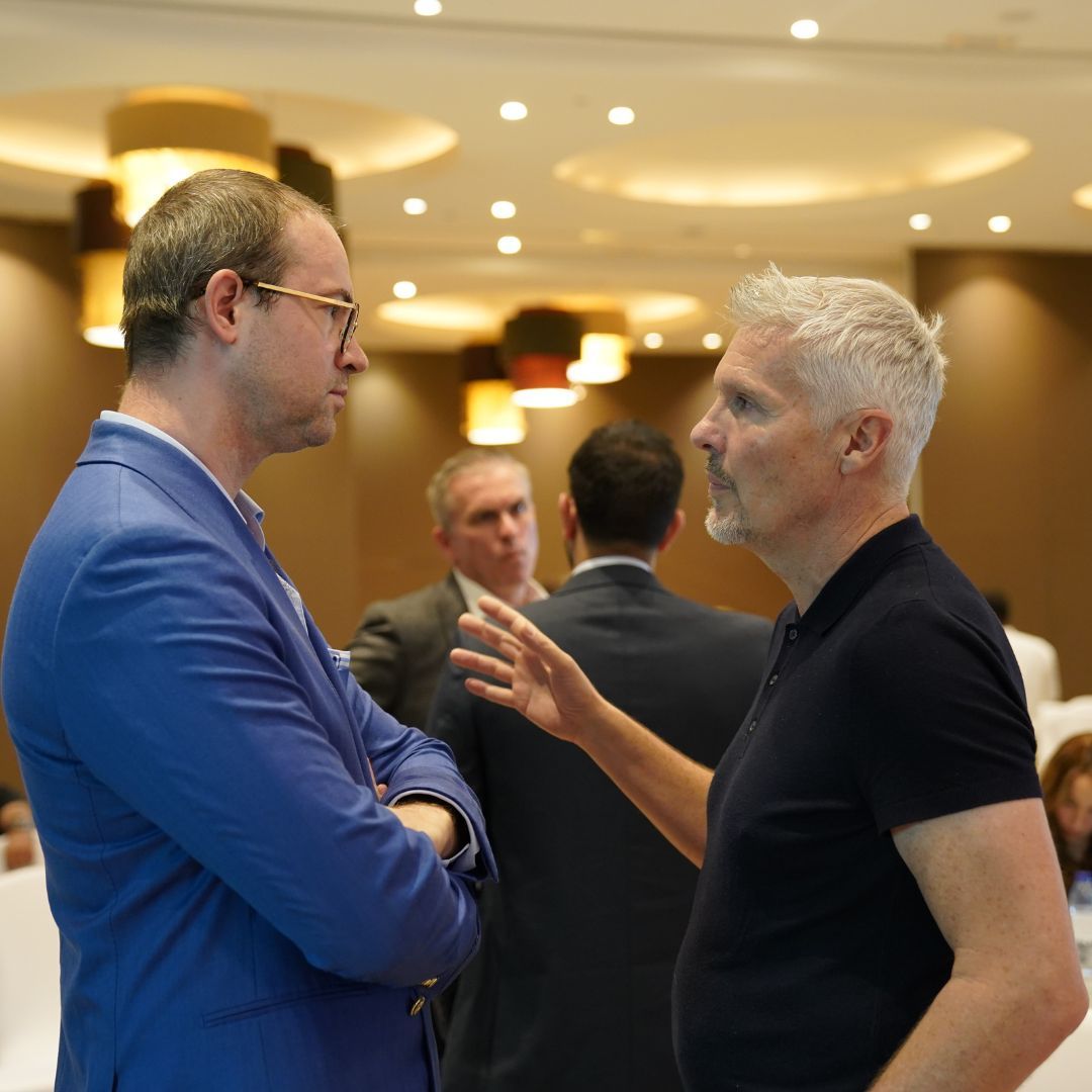 Executives in discussion in a hotel lobby between sessions.