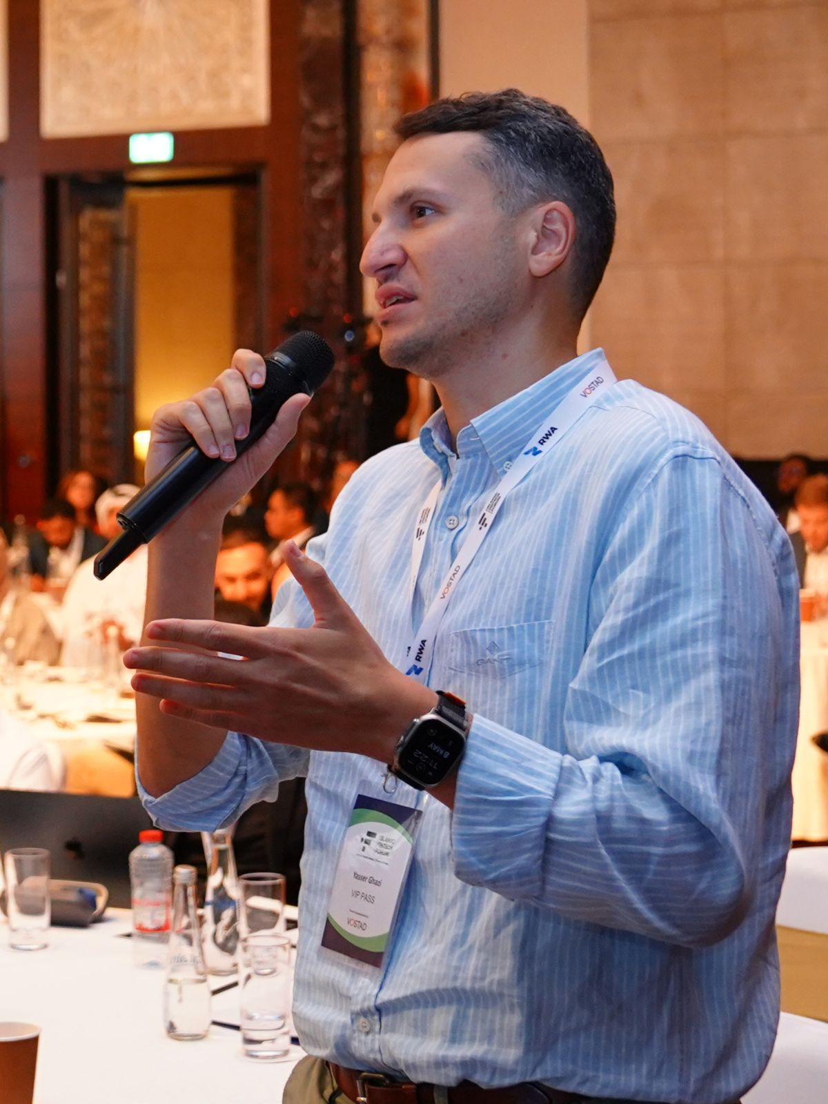 A delegate stands at his table with a microphone to put a question to the stage.